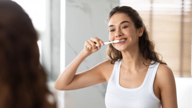 Frau mit Zahnbürste im Mund