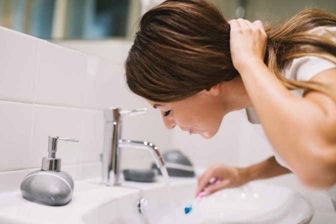 Eine Frau putzt die Zähne für ihre Mundhygiene 
