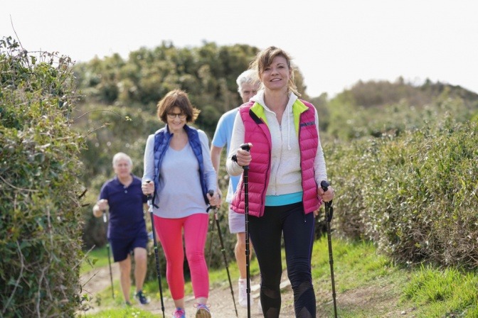 Eine Gruppe Menschen macht Nordic Walking um die Gelenke beim Sport zu schonen