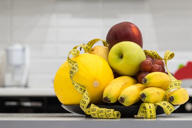 Ein Maßband umfasst Obst