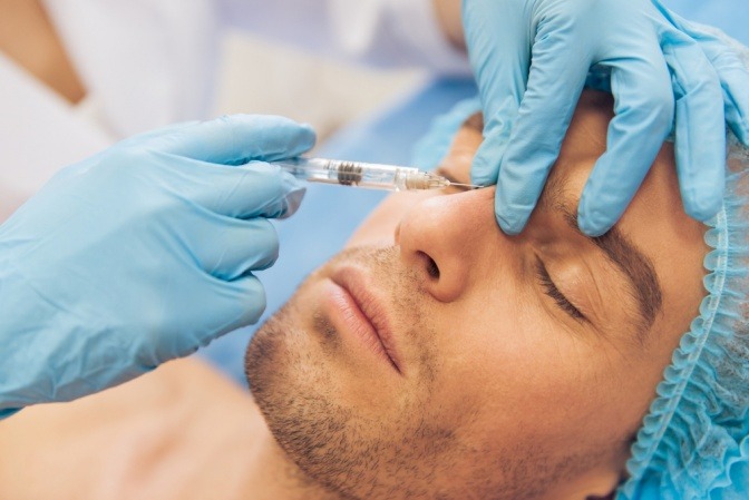 Mann während Botoxbehandlung im Gesicht