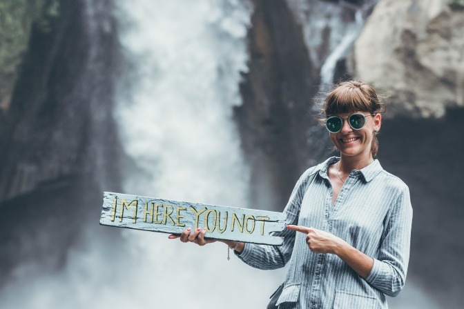 Eine Frau scheint respektlos und hat ein Schild in der Hand