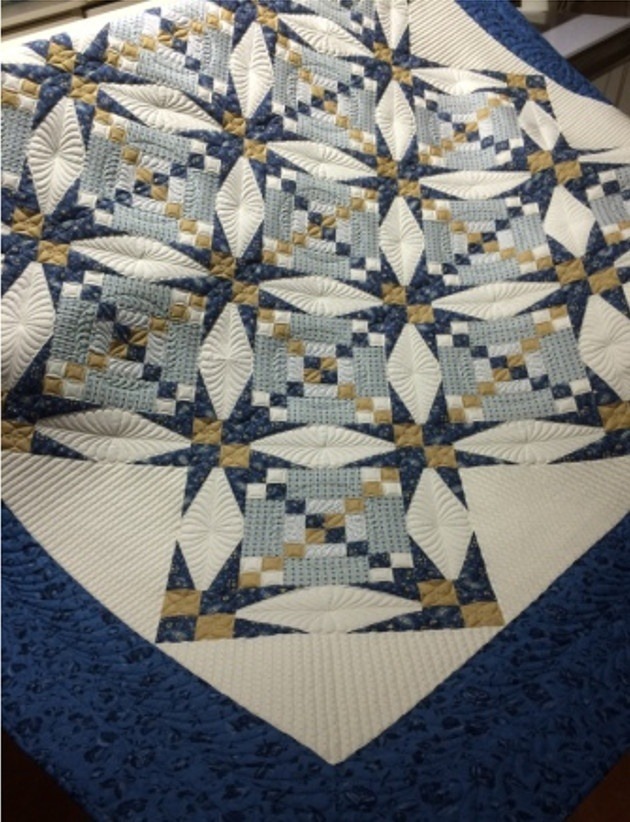 Das Muster dieser blauen Patchworkdecke erinnert an Sterne