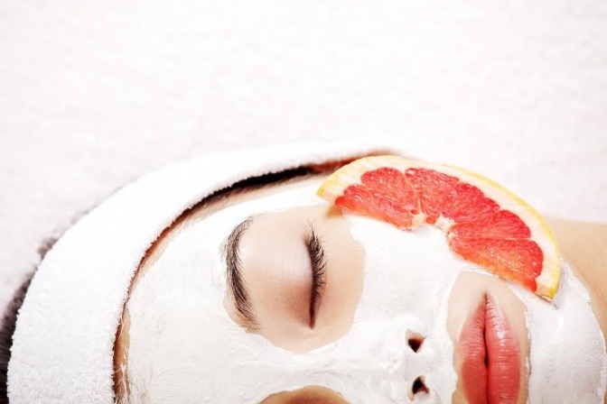 Frau mit Gesichtsmaske und Orangenscheibe