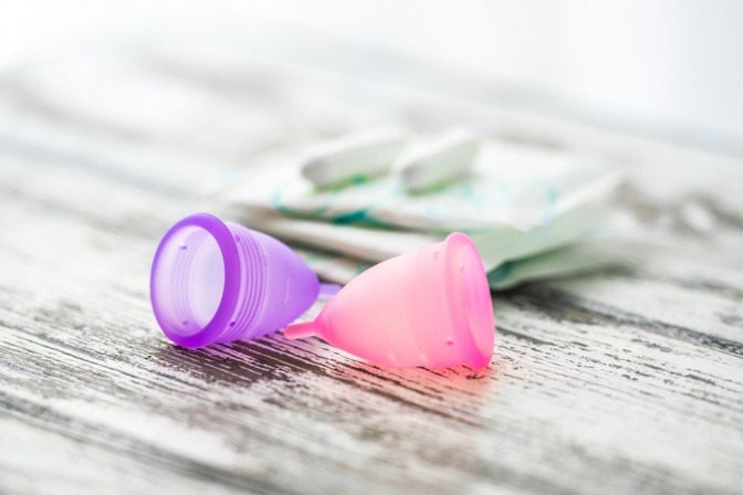 Periode Auffangbehälter (Menstruationstassen) liegen neben Tampons