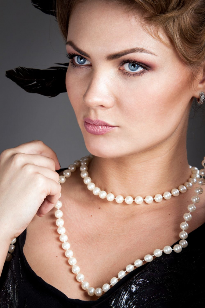 Eine Frau trägt als Halskette Perlenschmuck