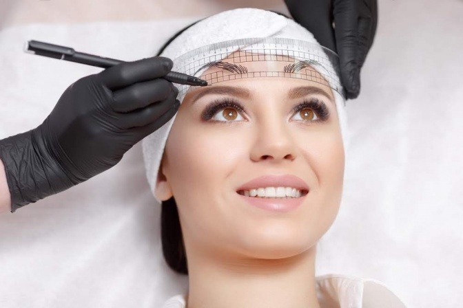 Auf einer Schablone sind Augenbrauen für ein Permanent Make-up