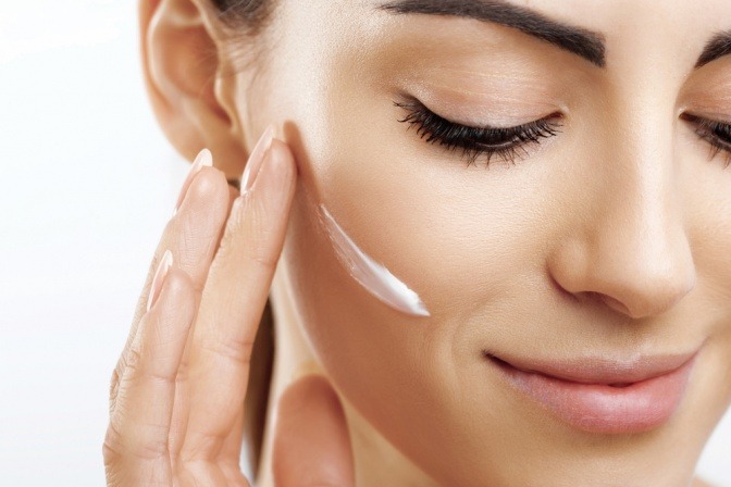 Frau mit Hautcreme im Gesicht