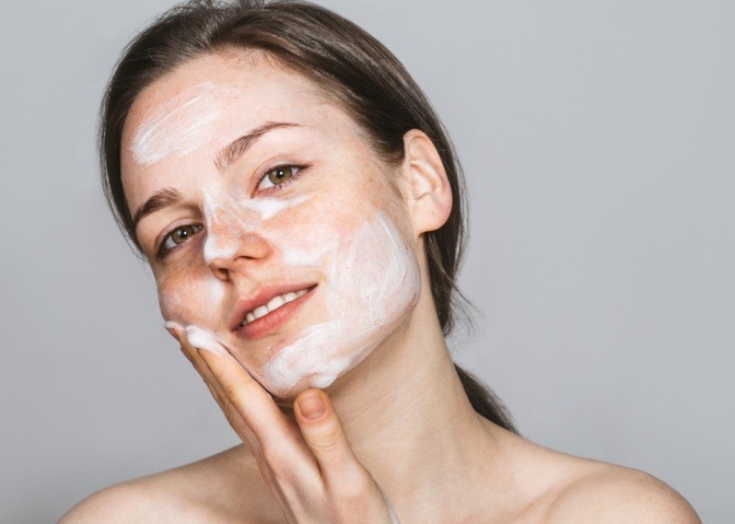 Frau beim Aufhellen von Pigmentflecken durch Creme
