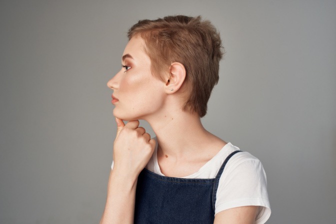 Pixie Cut bei einer jungen Frau mit roten Haaren. 