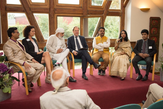 Die Teilnehmerinnen und Teilnehmer des Ayurveda Symposiums sind bei einer Podiumsdiskussion zu sehen