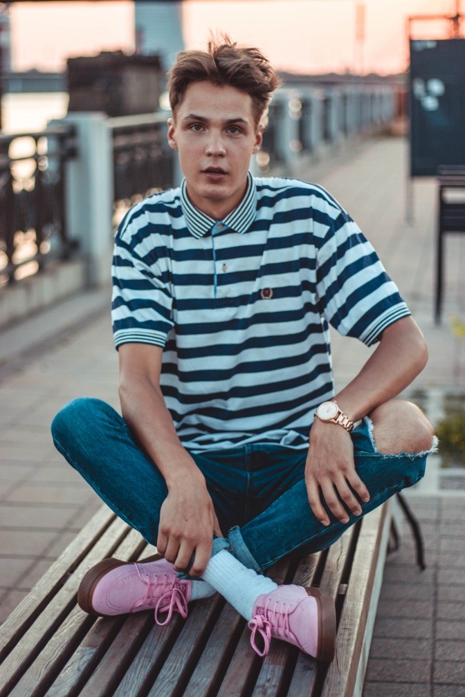Ein Mann trägt ein gestreiftes Polo-Shirt