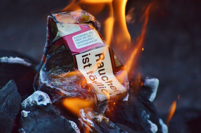 Eine Packung Zigaretten verbrennt im Feuer