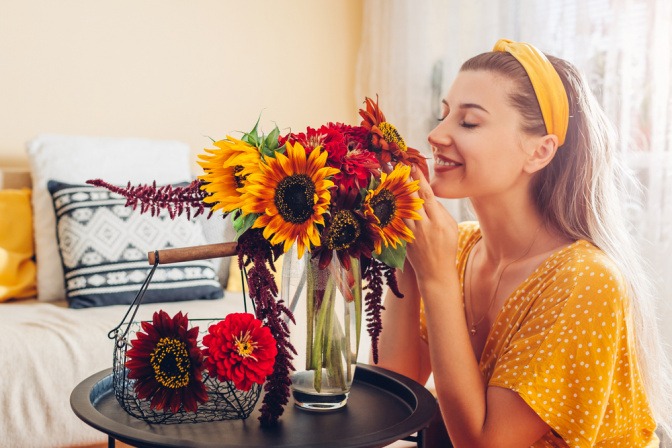 Frau riecht an einem Blumenstrauß