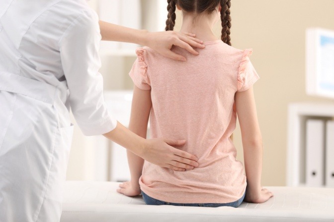 Kind mit Rückenschmerzen beim Kinderarzt