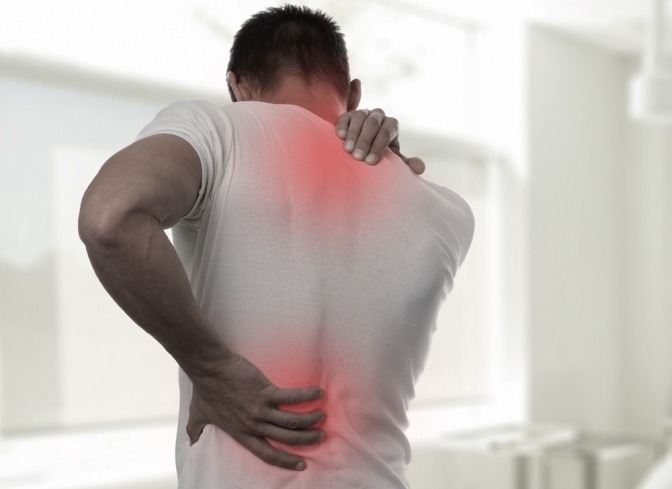 Die Rückenschmerzen eines Mannes sind an seiner Wirbelsäule rot eingezeichnet