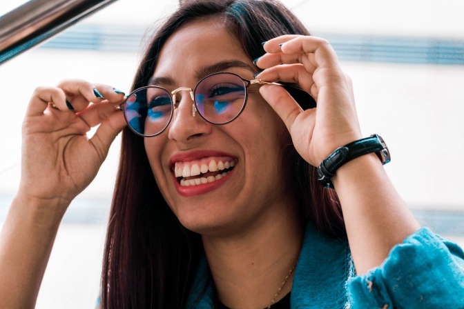 gut gelaunte Frau mit einer runde Brille