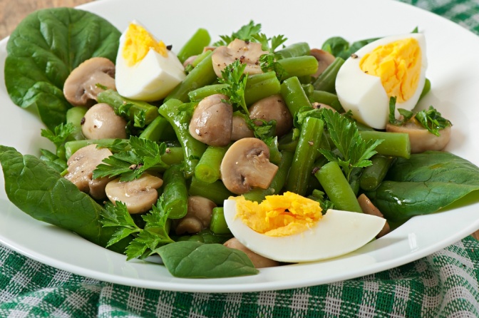 Ein Salat mit Pilzen und Eiern ist angerichtet