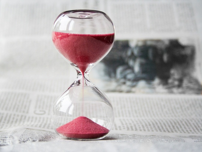 Eine Sanduhr steht auf einer Zeitung