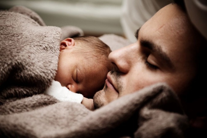 Baby schläft auf einem erwachsenen Mann