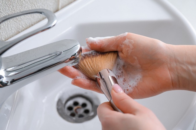 Frau reinigt ihre Make-up-Pinsel