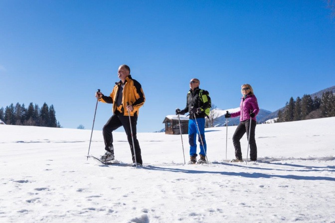Eine Gruppe Menschen geht Schneeschuhwandern