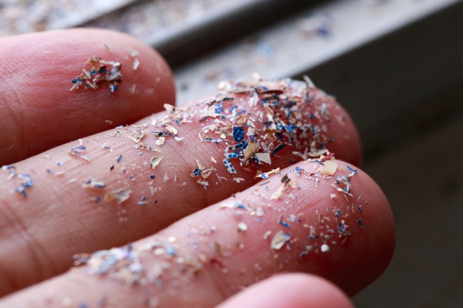 Kleine Teilchen aus Plastik auf Fingern