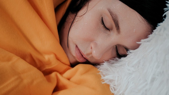 Eine Frau schwitzt gegen Erkältung im Bett