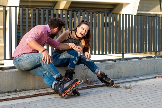 Paar macht eine Pause beim gemeinsamen Rollerskaten.