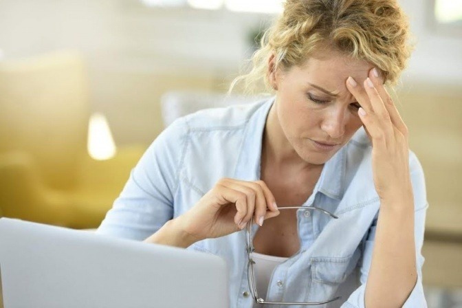 Eine Frau hat Sehstörungen durch Stress und Kopfschmerzen