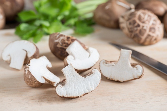 Shiitake Pilze liegen geschnitten auf einem Brett