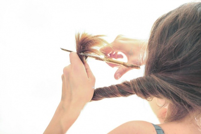 Eine Frau schneidet selbst ihre Haare
