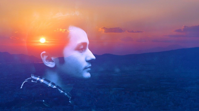 Doppelt multipliziertes Exposure-Portrait eines jungen Mannes im Freien bei Sonnenaufgang 