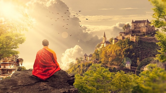 Ein Mönch sitzt auf einem Berg und sieht zum Kloster