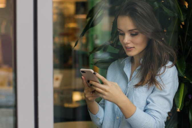 Eine Frau tippt am Smartphone