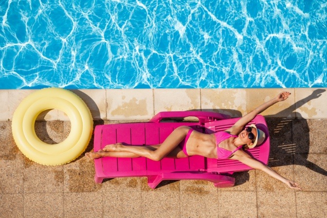 Frau am Pool beim Sonnen