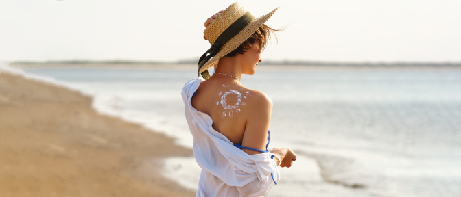 Sonnencreme in Form einer Sonne auf der Schulter einer Frau