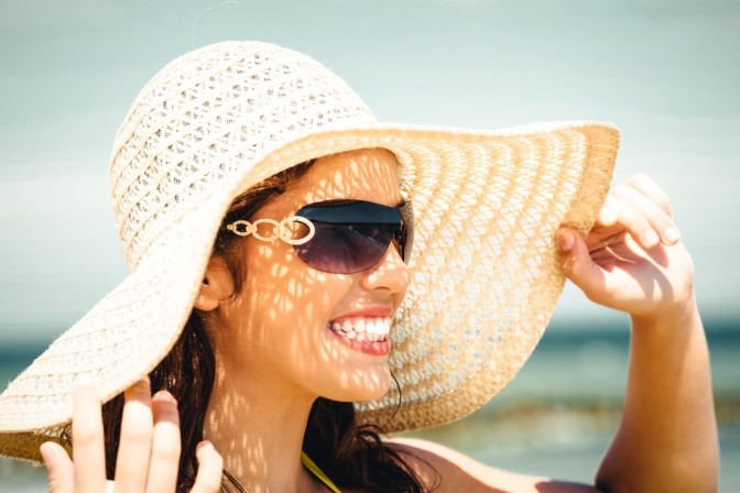 Frau mit Sonnenhut und Sonnenbrille