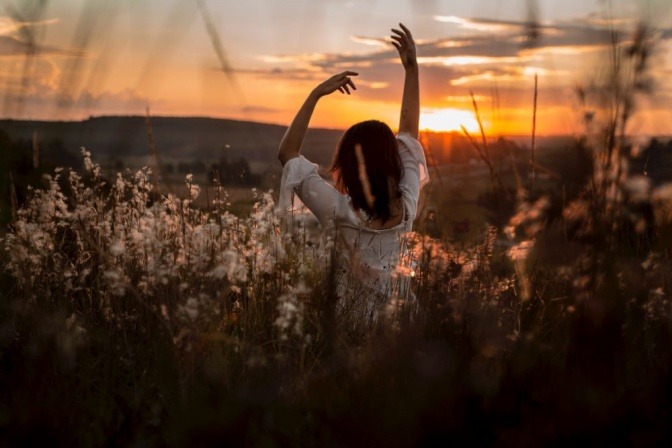 Eine Frau macht im Sonnenuntergang eine Yoga-Pose