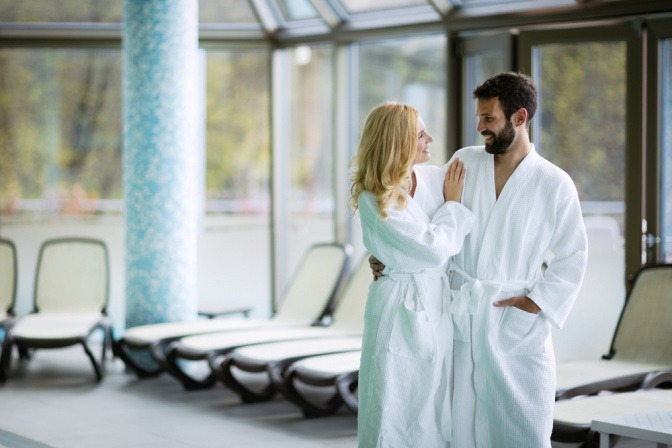 Ein Mann und eine Frau tragen einen Bademantel im Spa Bereich