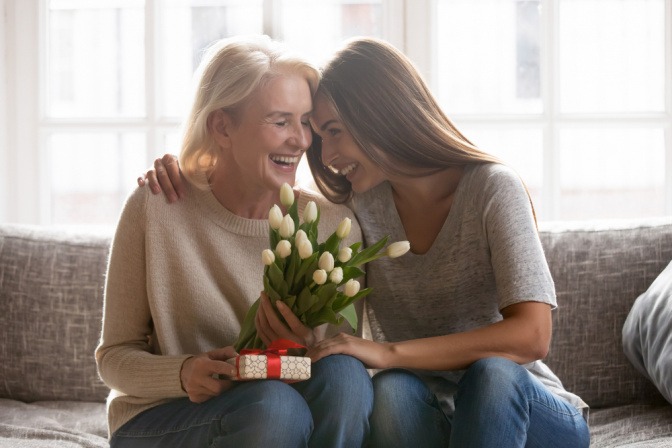 Eine junge Frau beschenkt eine ältere Frau, die sich sehr darüber freut