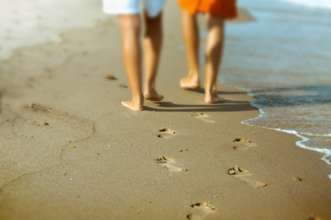 Zwei Personen gehen am Strand spazieren