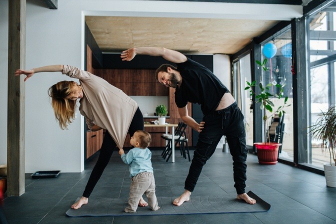 Ein Paar macht Sport gegen Stress, ein Kind zerrt währenddessen am Trikot der Mutter.