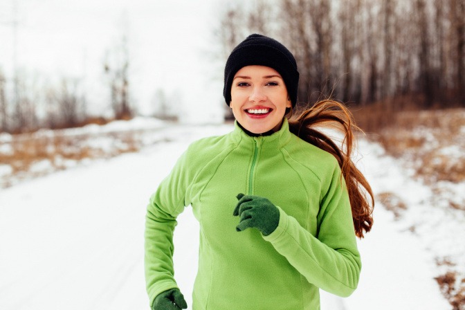 Frau beim Joggen im Schnee.
