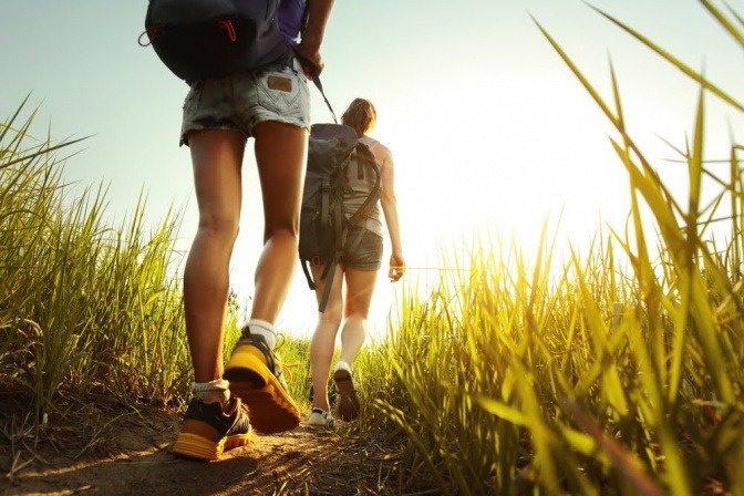 Zwei Menschen wandern mit der richtigen Sportkleidung bei Hitze