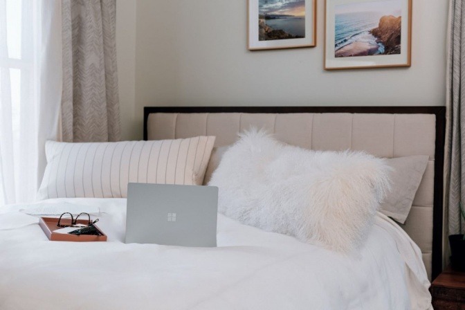 Auf einem Bett liegt ein Laptop als Störquelle im Schlafzimmer