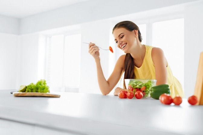 Eine Frau macht eine Stoffwechseldiät und isst Gemüse
