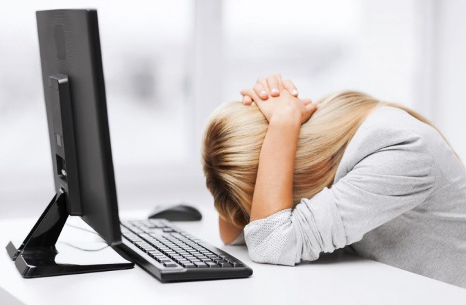 Eine Frau hat wegen Stress in der Arbeit den Kopf am Tisch