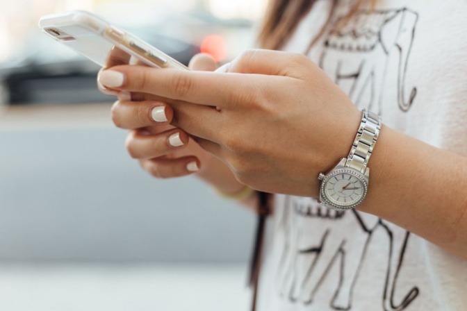 Eine Frau tippt auf Ihrem Telefon bzw. Smartphone