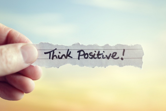Ein Zettel mit der Aufschrift Think positive ist zu sehen